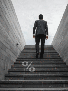 Businessman climbing steps with percentage symbol — concept of financial growth, interest rates, and insurance planning.